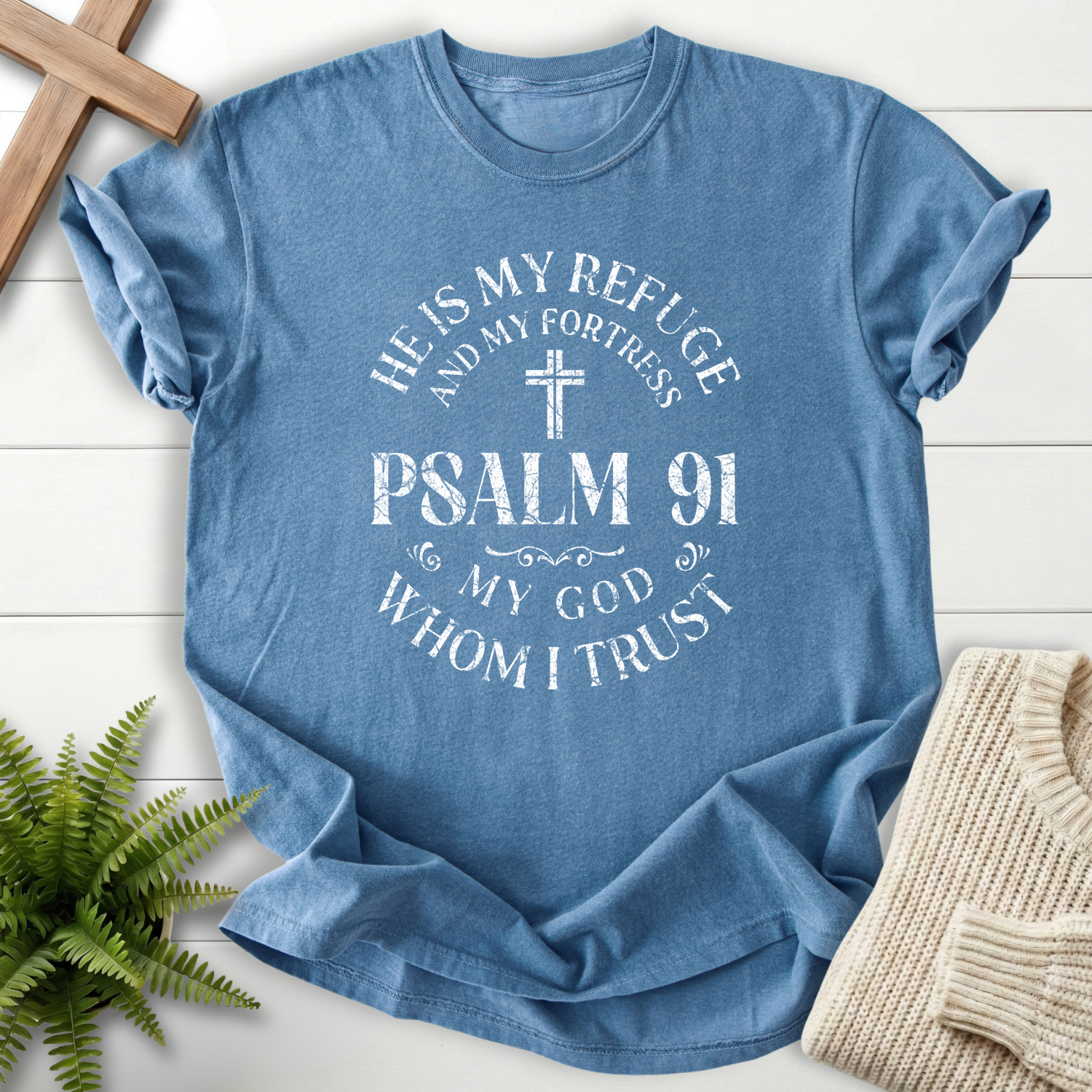 Blue Jean Bible verse tee with a Psalm 91 refuge badge, cross, and 'He is My Refuge and My Fortress' lettering, inspired by Psalm 91.