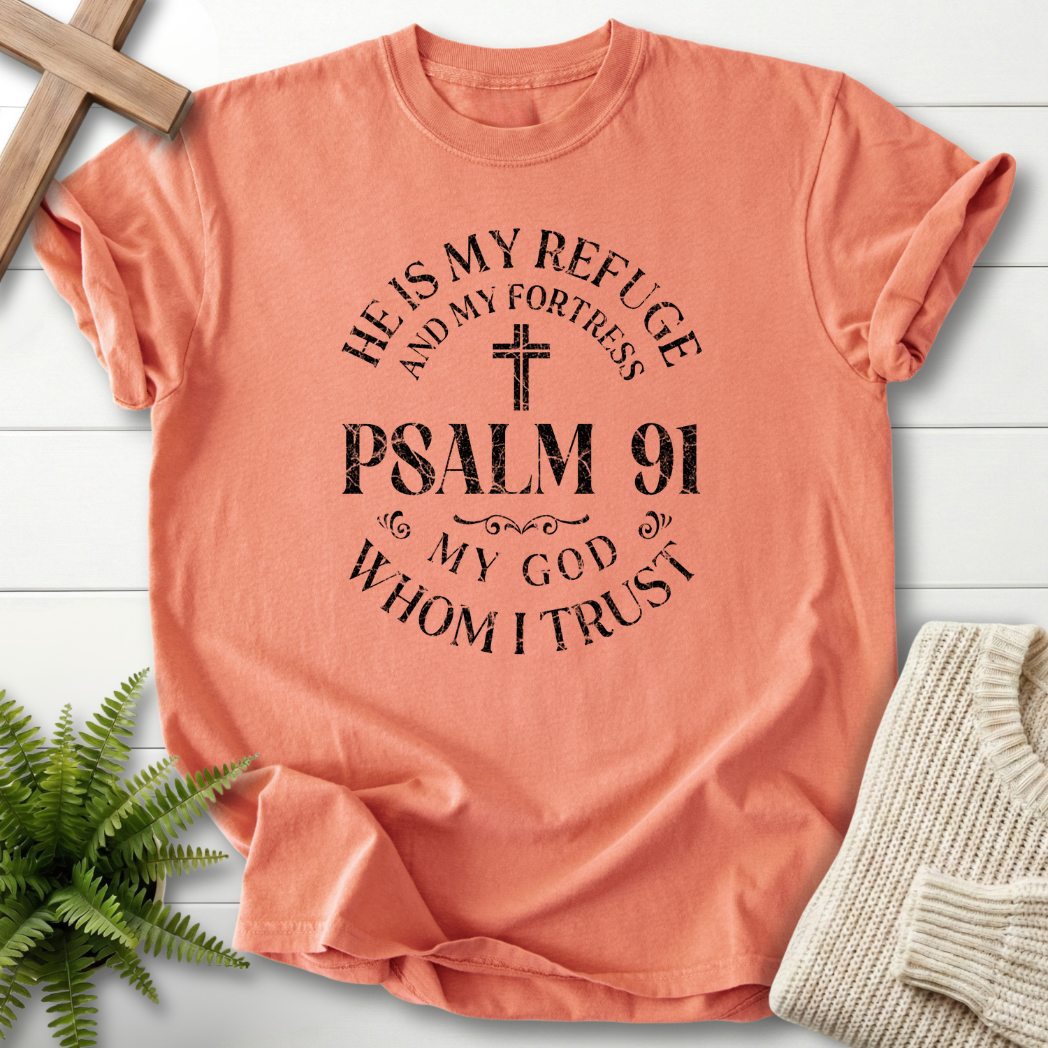 Terracotta women's faith t-shirt with a circular Psalm 91 badge and 'He is My Refuge, My God Whom I Trust' lettering, inspired by Psalm 91.