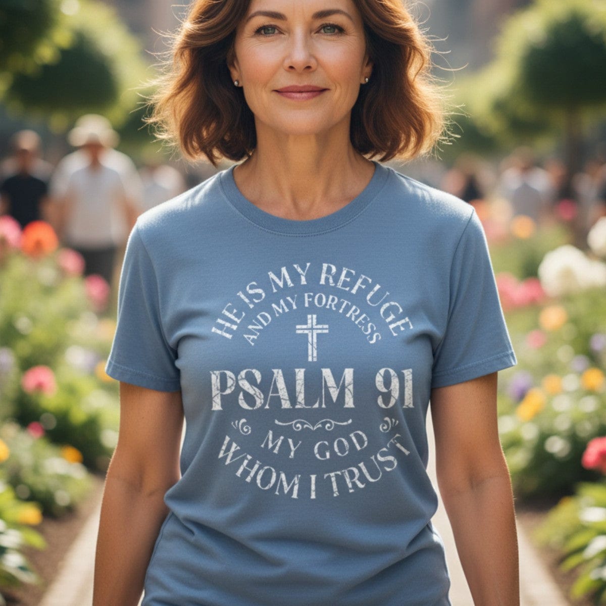 Smiling woman outdoors wearing a Comfort Colors 1717 blue jean “He Is My Refuge and My Fortress – Psalm 91 My God Whom I Trust” t-shirt. A modern Christian shirt expressing strength and trust in God — elegant women’s scripture tee and Christian mom gift idea.