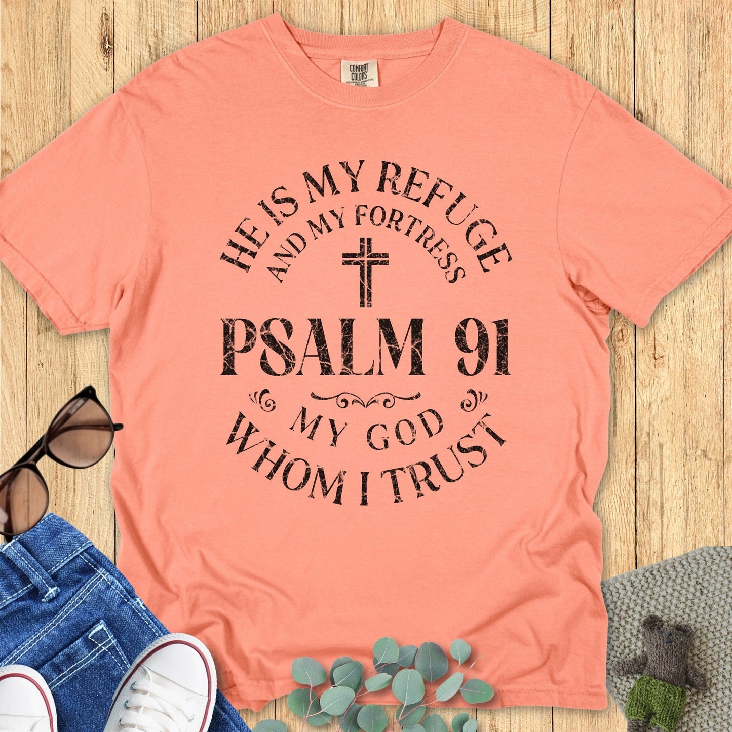 Flatlay of a Comfort Colors 1717 terracotta “He Is My Refuge and My Fortress – Psalm 91 My God Whom I Trust” t-shirt with a rustic cross design. A bold and uplifting women’s scripture tee — perfect faith-based apparel for women and meaningful Christian mom gift idea.