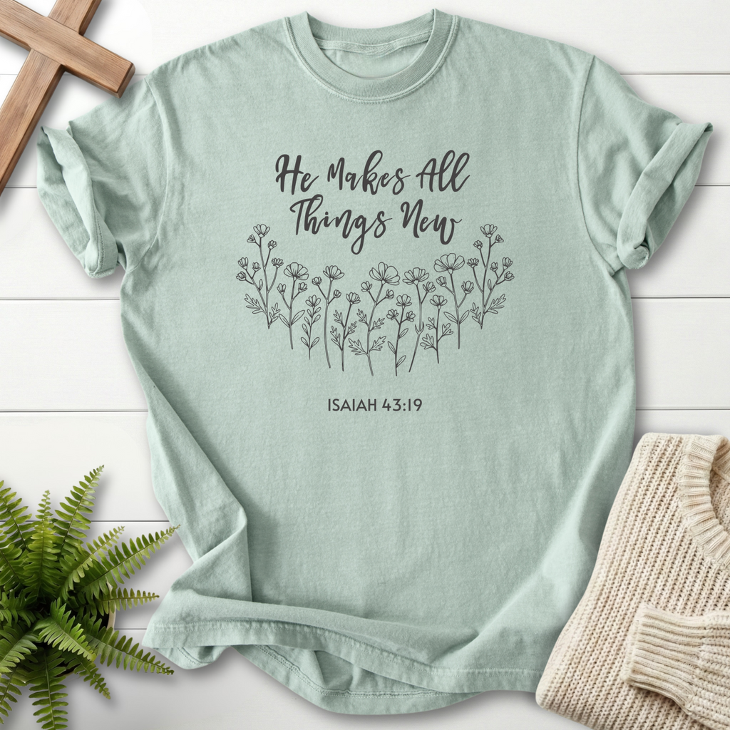 Bay women's faith t-shirt with delicate wildflower line art and 'He Makes All Things New' script, inspired by Isaiah 43:19.