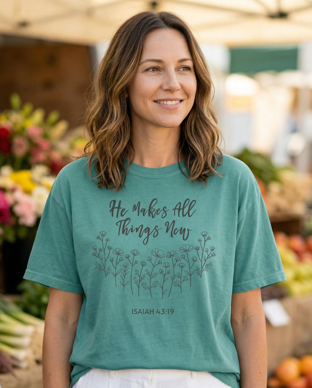 All Things New – Chalky Mint women's Christian tee, lifestyle photo in farmers market – Script lettering 'He Makes All Things New' above a row of delicate lin – Isaiah 43:19 – She Wears Faith
