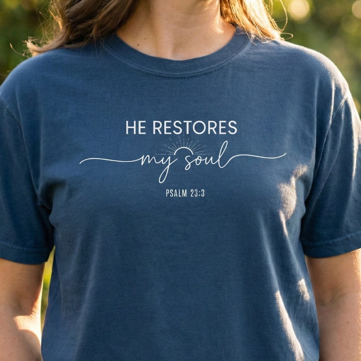 Midnight blue Christian Women's T-Shirt featuring white typography that reads "He Restores My Soul Psalm 23:3" with a sunrise graphic.