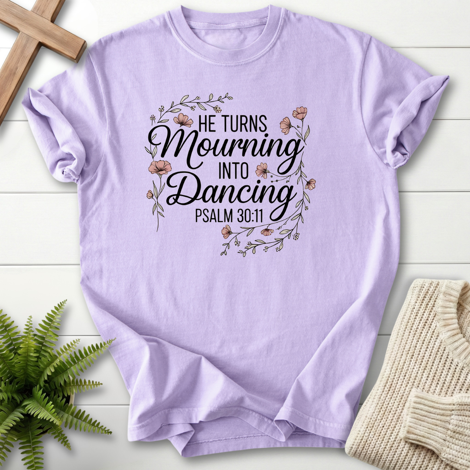 Orchid women's Christian t-shirt with floral wreath artwork and "He Turns Mourning Into Dancing," inspired by Psalm 30:11