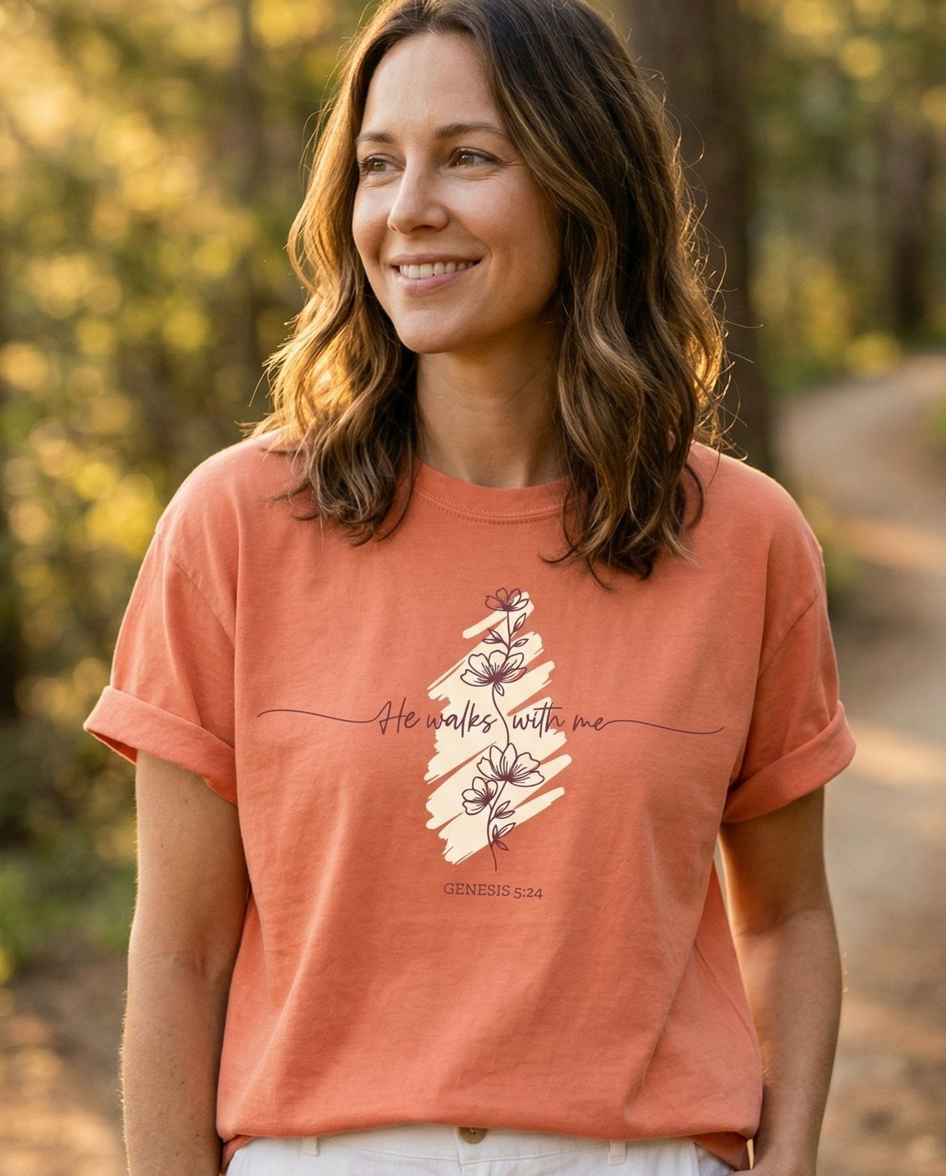 Walk With God T-shirt – Terracotta women's Christian tee, lifestyle photo in nature trail – Cursive 'He walks with me' lettering over a brushstroke stripe with de – Genesis 5:24 – She Wears Faith