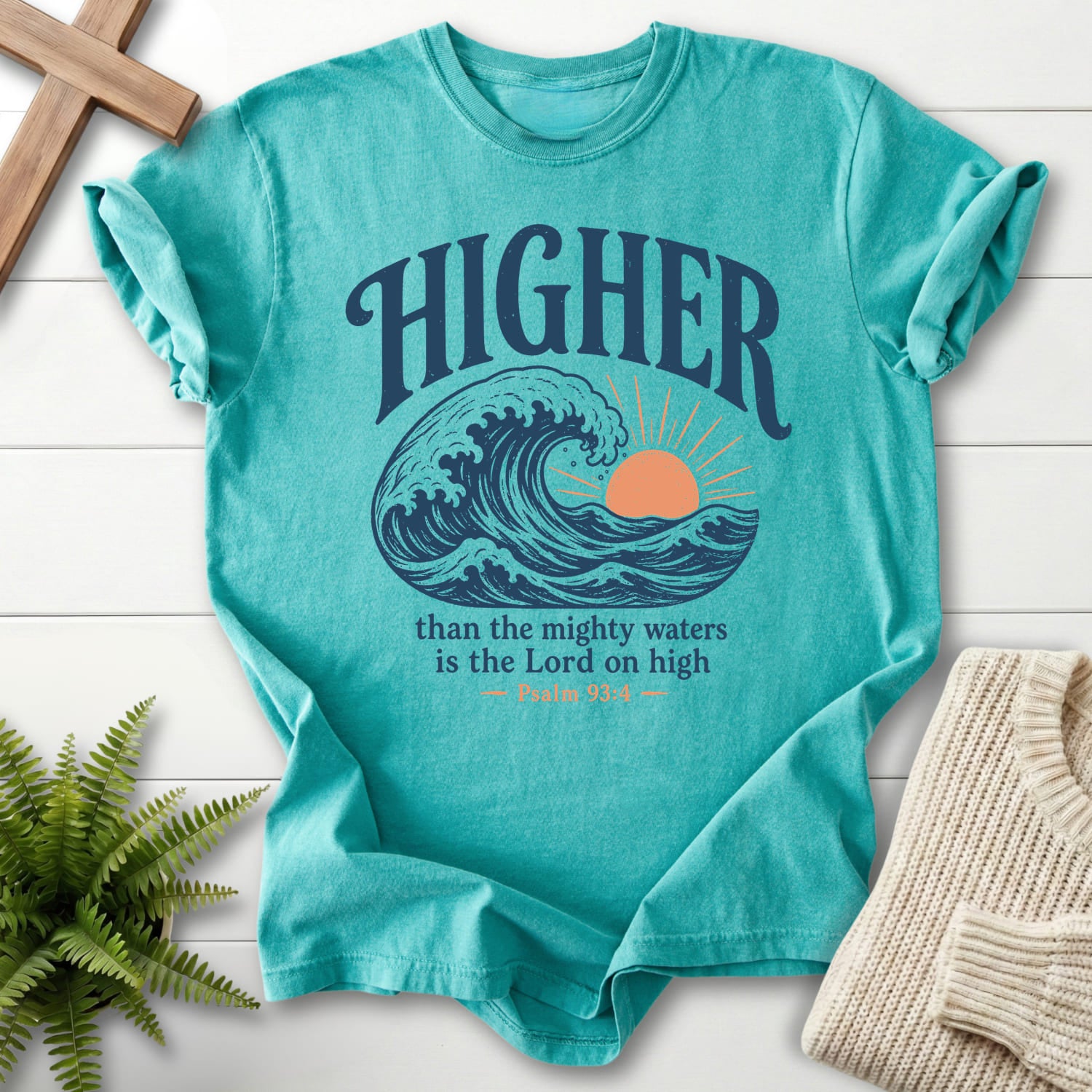 Flat lay of a Seafoam Comfort Colors 1717 garment-dyed Christian tee featuring sunrise graphic with "Higher Than the Mighty Waters T-Shirt".