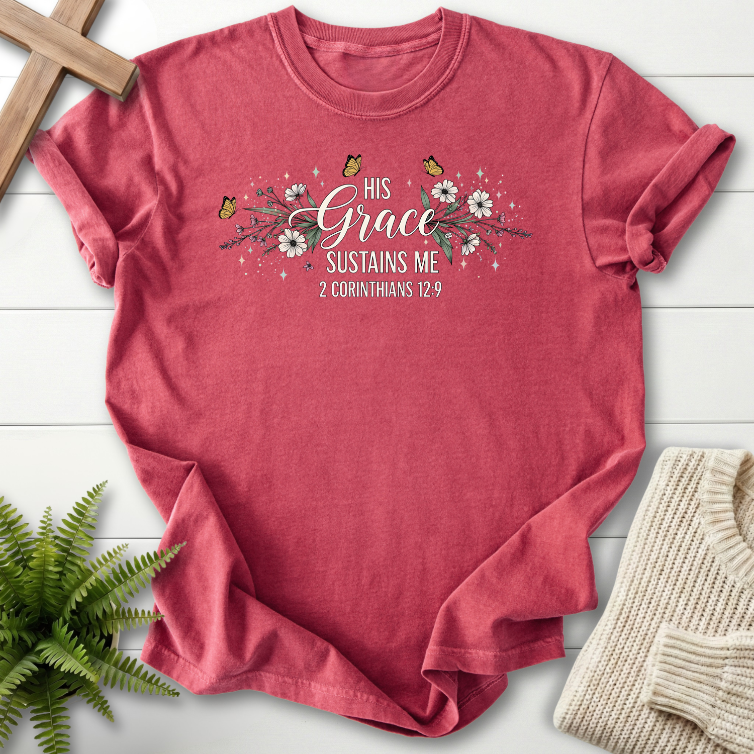 Crimson women's Christian t-shirt with floral and butterfly art and "His Grace Sustains Me," inspired by 2 Corinthians 12:9