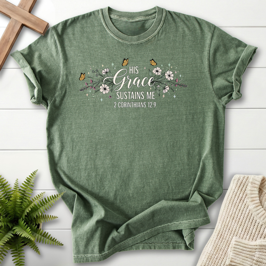 Moss women's Christian t-shirt with a floral garland, butterflies, and "His Grace Sustains Me," inspired by 2 Corinthians 12:9