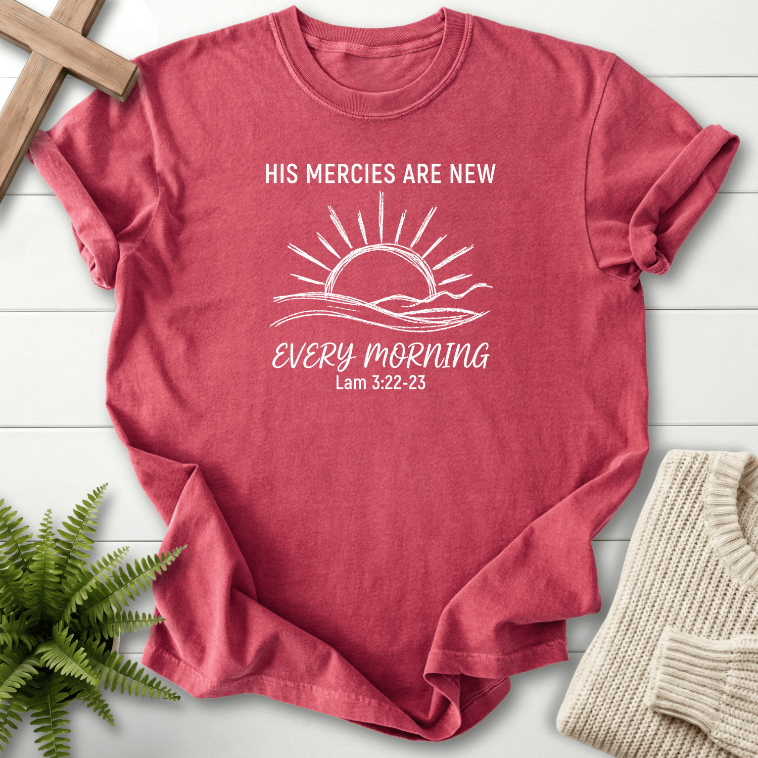 Crimson women's Christian t-shirt with a sunrise over rolling hills and "His Mercies Are New Every Morning," inspired by Lamentations 3:22-23.