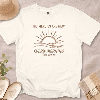 Flat lay of an Ivory Comfort Colors 1717 tshirt with a sun and waves illustration. A spiritual Christian women tee with the Bible verse "His Mercies Are New Every Morning," designed for US faith wear collections.