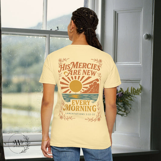 Back view of a banana yellow Christian women’s tee with warm-toned sunrise artwork and the phrase “His Mercies Are New Every Morning – Lamentations 3:22–33.”