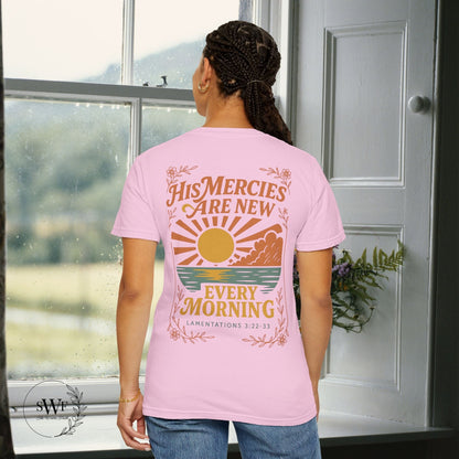 Back view of a light pink blossom Christian t-shirt with floral accents and a sunrise graphic reading “His Mercies Are New Every Morning – Lamentations 3:22–33.”