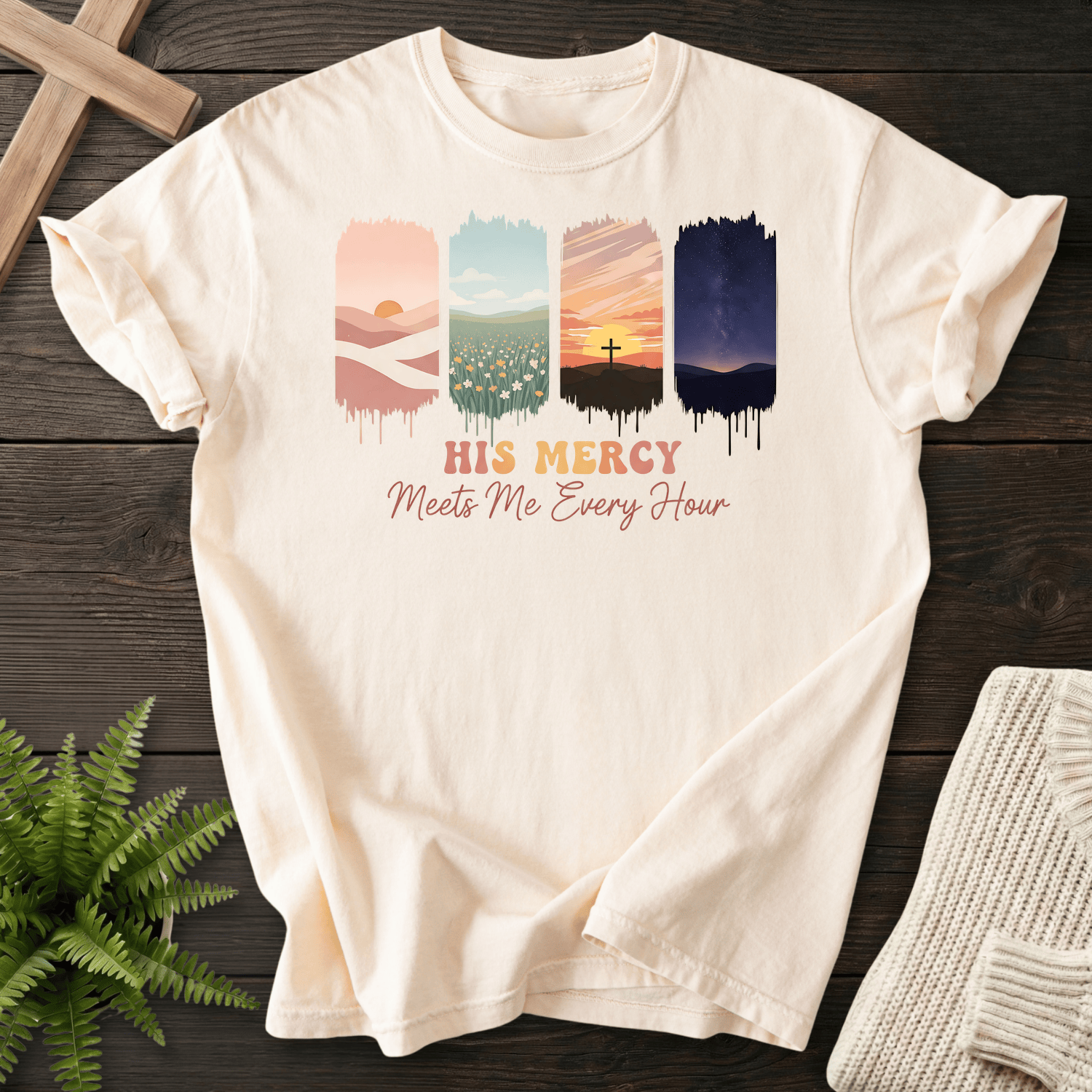 Ivory women's Christian t-shirt with four landscape panels showing sunrise, meadow, cross, and night sky