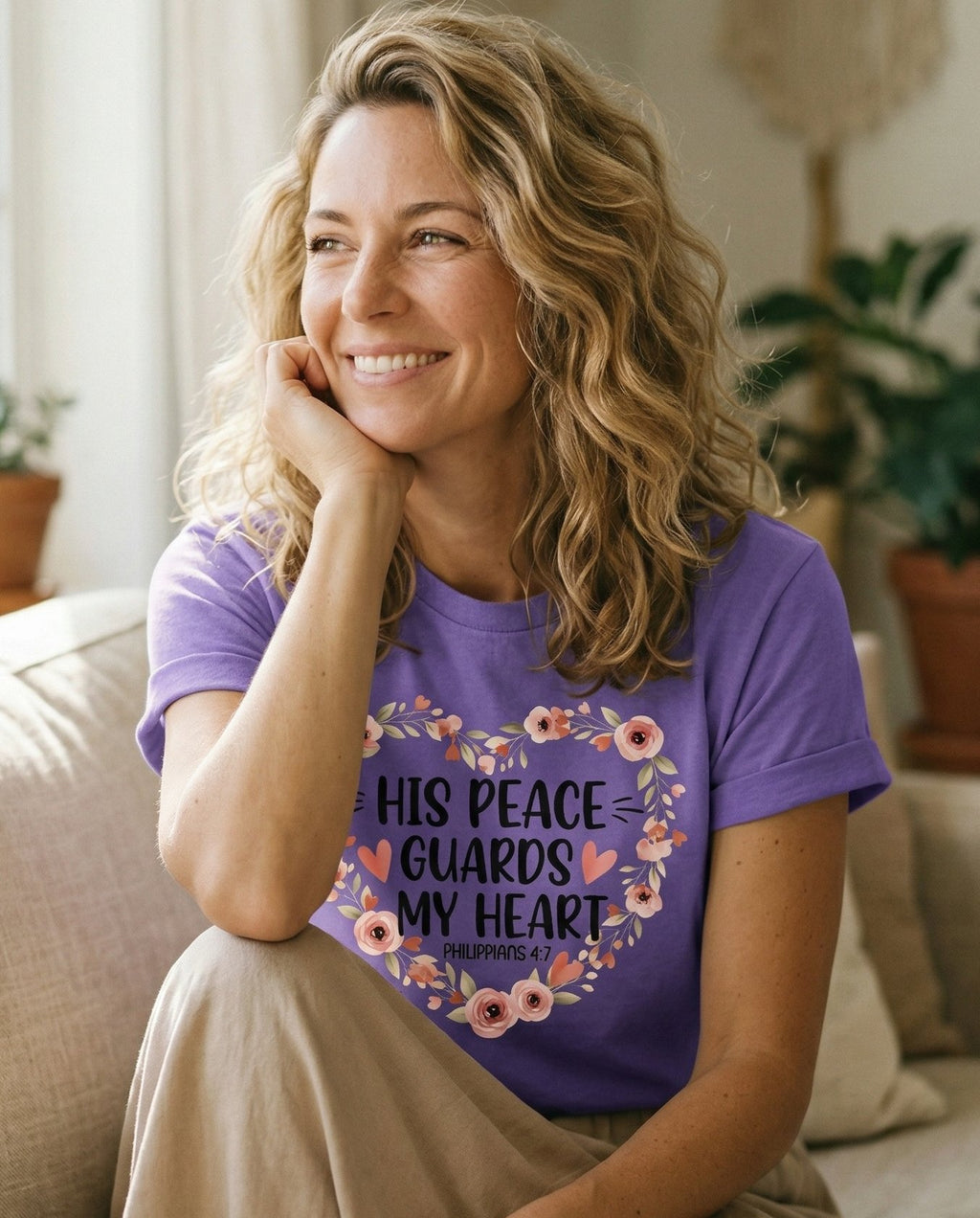 Peace Guards Heart – Violet women's Christian tee, lifestyle photo in cozy living room – Floral heart wreath made of roses and leaves framing 'His Peace Guards – Philippians 4:7 – She Wears Faith