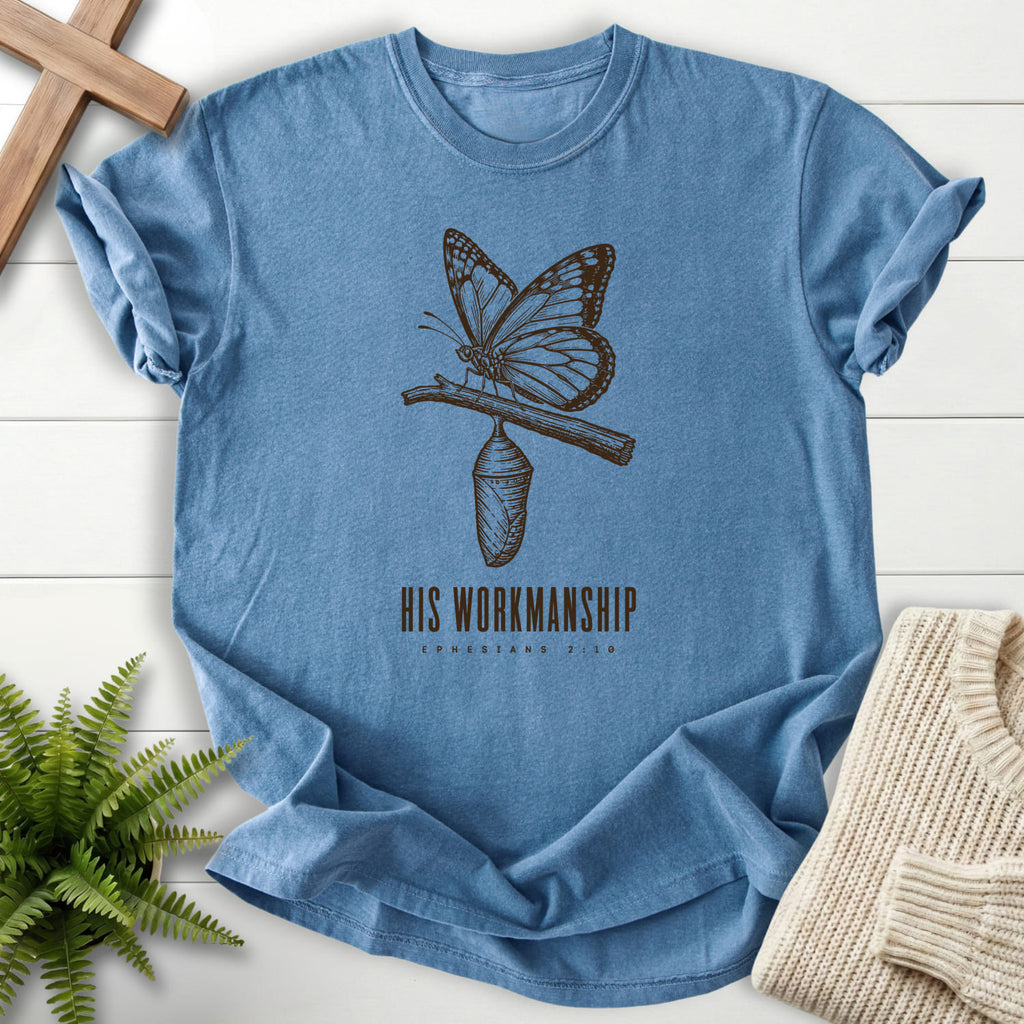 Flatlay of a Blue Jean Comfort Colors 1717 garment-dyed Christian tee with butterfly artwork with "His Workmanship T-Shirt".