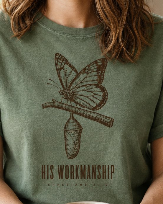 His Workmanship - Moss women's Christian tee, lifestyle photo in morning kitchen setting - Engraved butterfly emerging above a chrysalis - Ephesians 2:10 - She Wears Faith