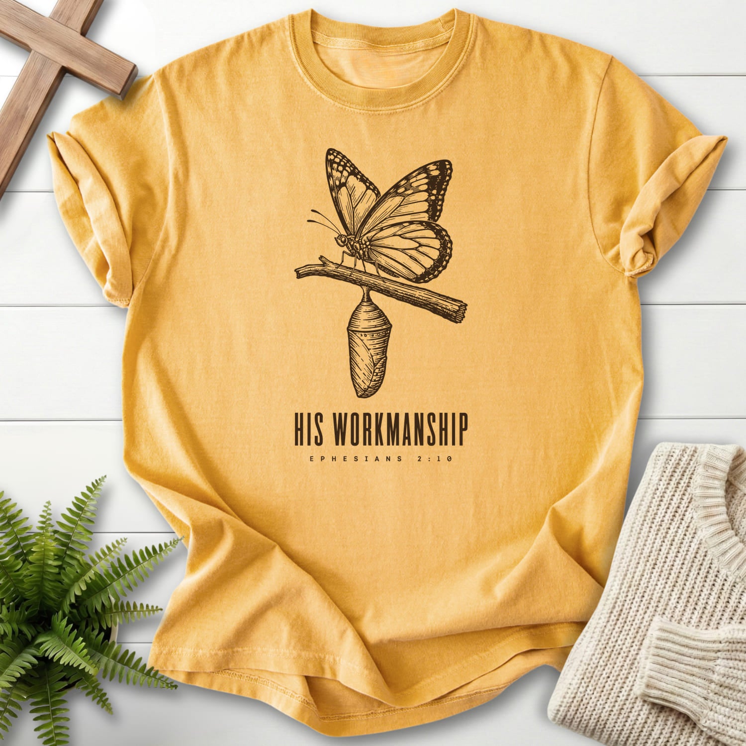 Flat lay of a Mustard Comfort Colors 1717 Christian t-shirt for women featuring butterfly artwork with "His Workmanship T-Shirt".