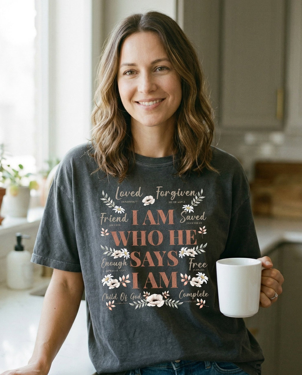 Who He Says I am – Pepper women's Christian tee, lifestyle photo in morning kitchen setting – Dense typographic design with 'I Am Who He Says I Am' as the central t – She Wears Faith
