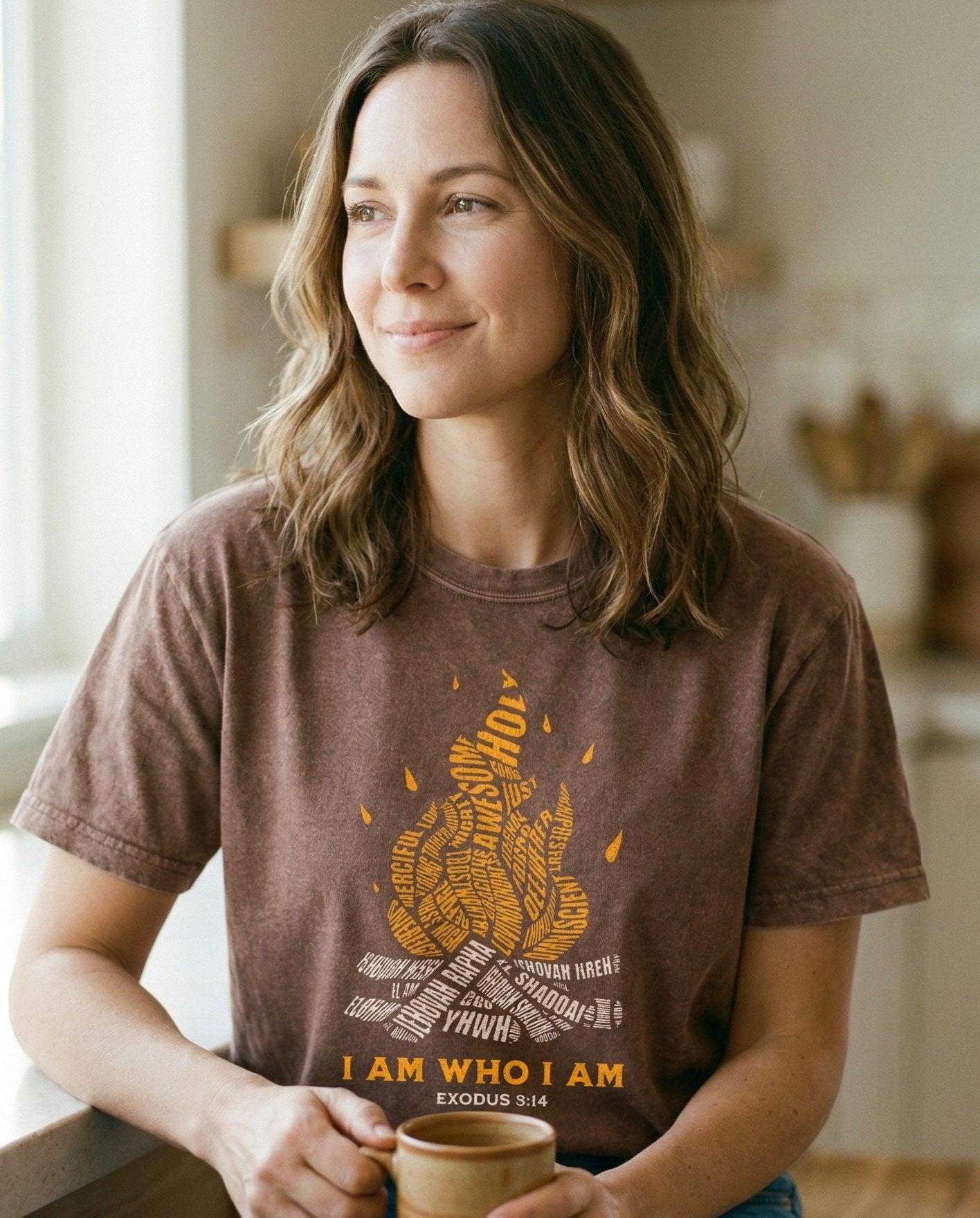 I AM WHO I AM – Espresso women's Christian tee, lifestyle photo in morning kitchen setting – Campfire illustration with names of God (YHWH – Exodus 3:14 – She Wears Faith
