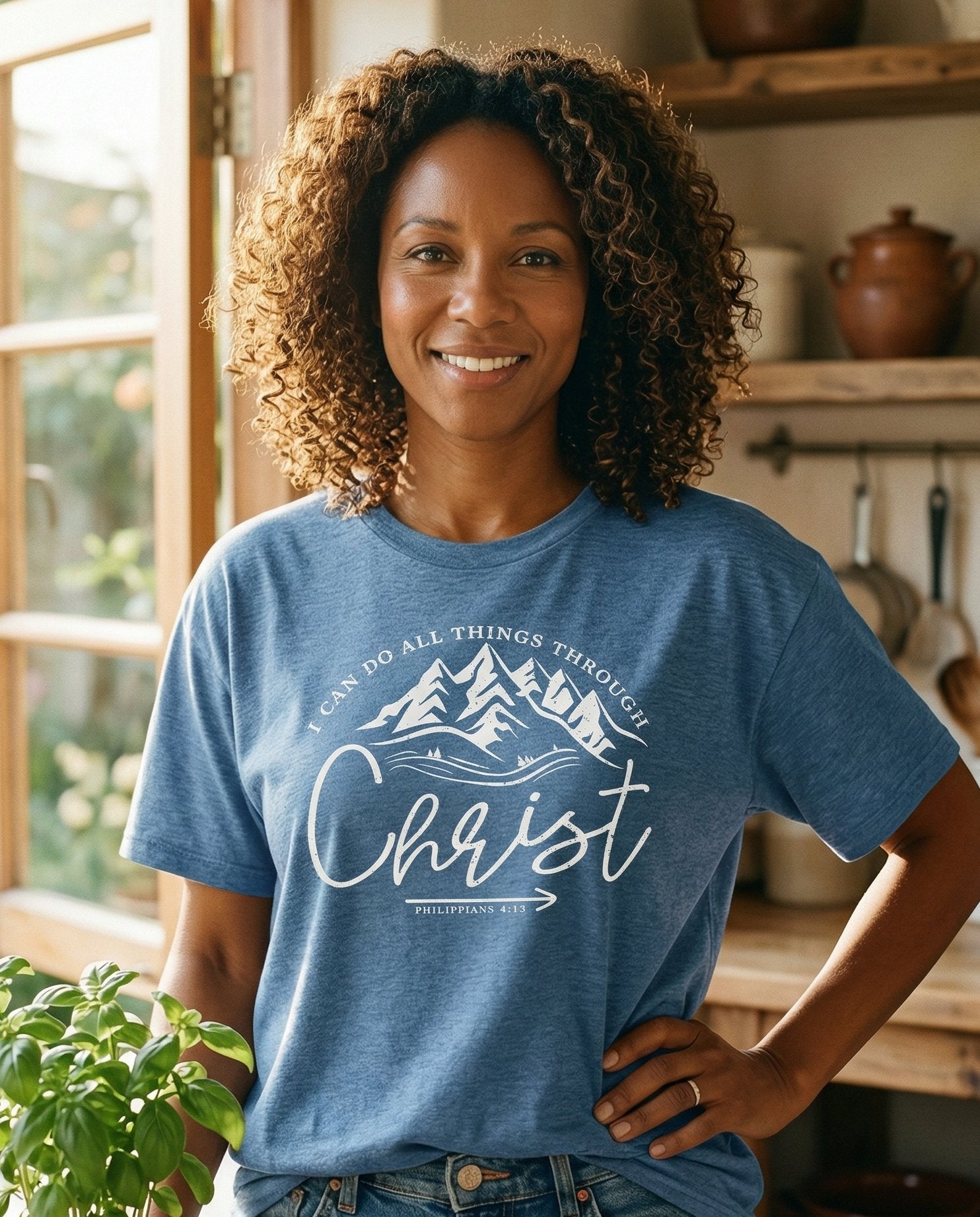 I Can Do All Things T-shirt – Blue Jean women's Christian tee, lifestyle photo in morning kitchen setting – Circular mountain landscape with pine trees and a scripture arc readin – Philippians 4:13 – She Wears Faith