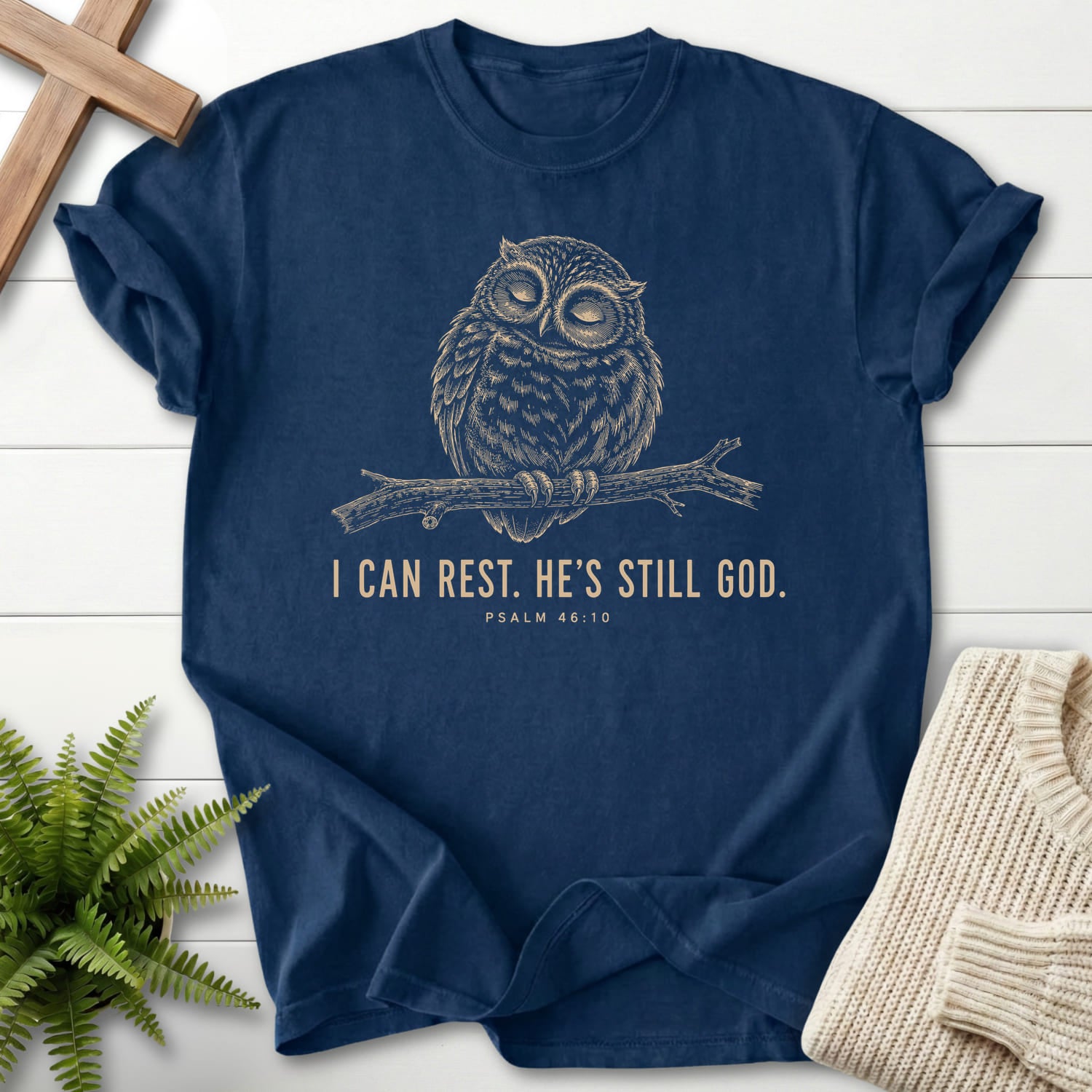 Flatlay of a Navy Bible verse tee with "He is Still God T-Shirt" Psalm 46:10 For faith wear collections.