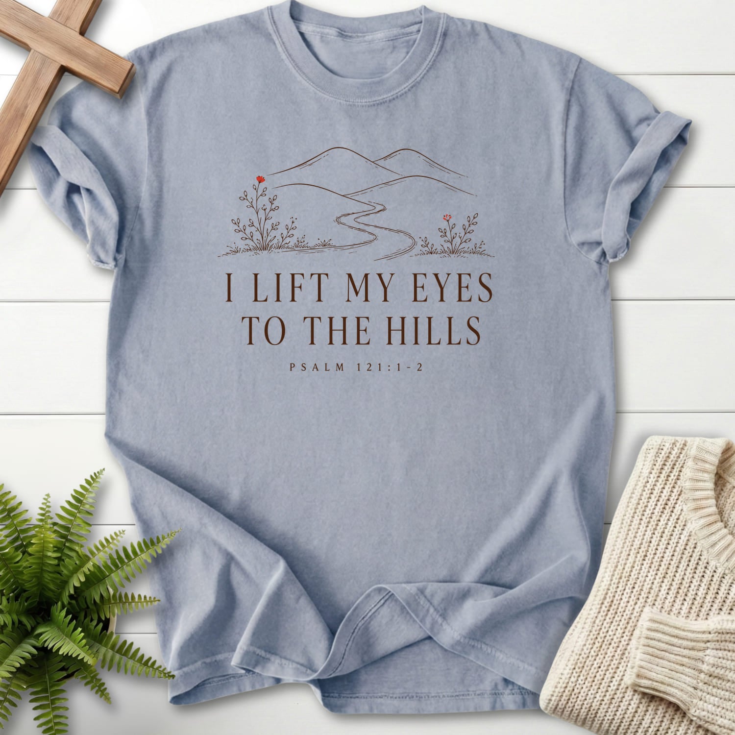 Flat lay of a Granite Christian shirt featuring floral line art with "I Lift My Eyes to the Hills T-Shirt" Psalm 121:1-2.