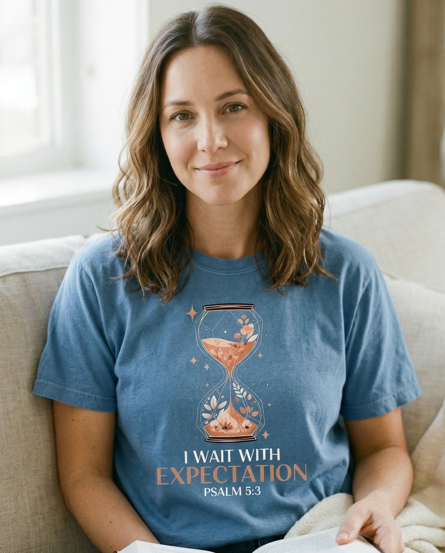 Wait With Expectation – Blue Jean women's Christian tee, lifestyle photo in cozy living room – Decorative hourglass illustration with florals and sparkles inside the – Psalm 5:3 – She Wears Faith