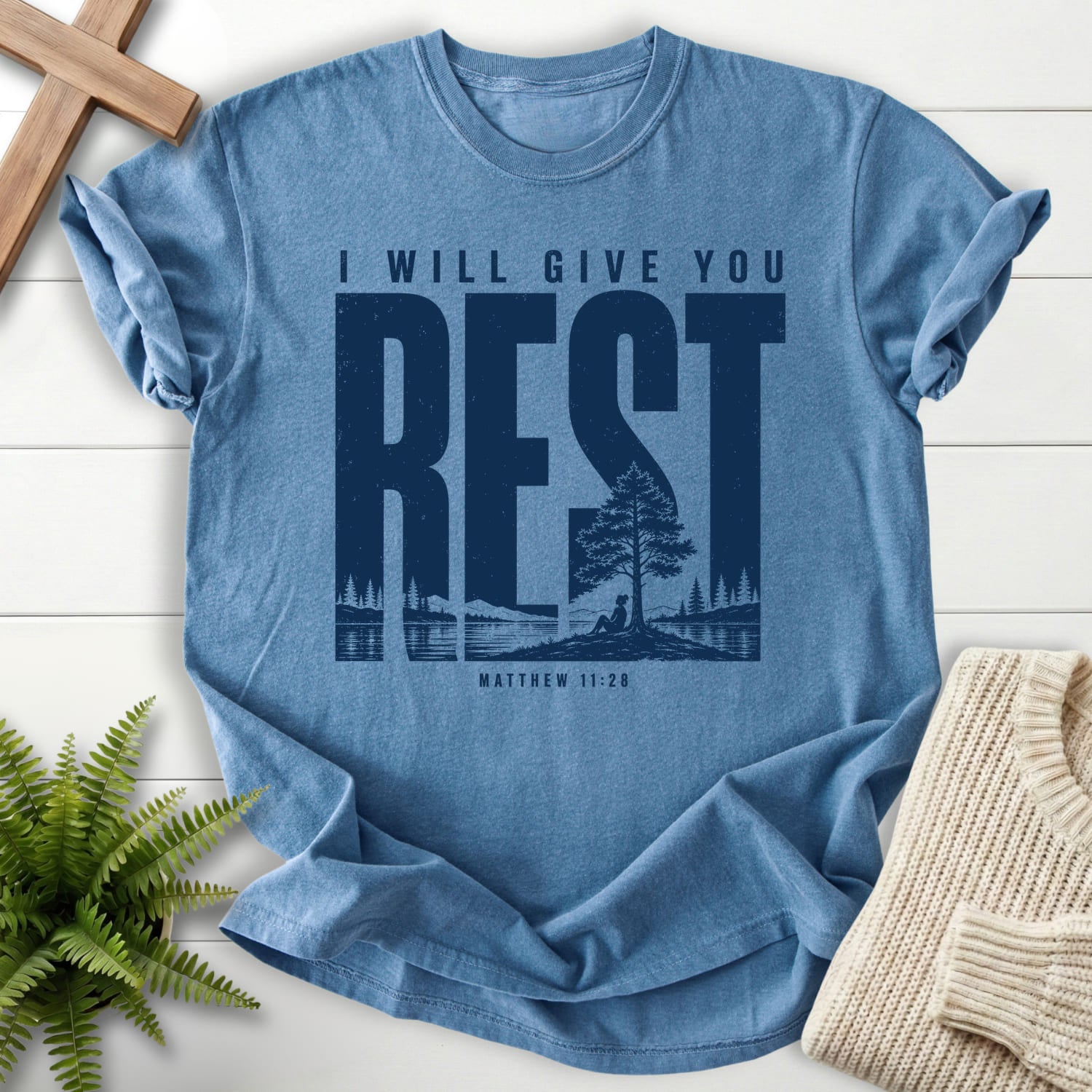 Flatlay of a Blue Jean Christian t-shirt for women with "I Will Give You Rest T-Shirt" Matthew 11:28 From Printify.