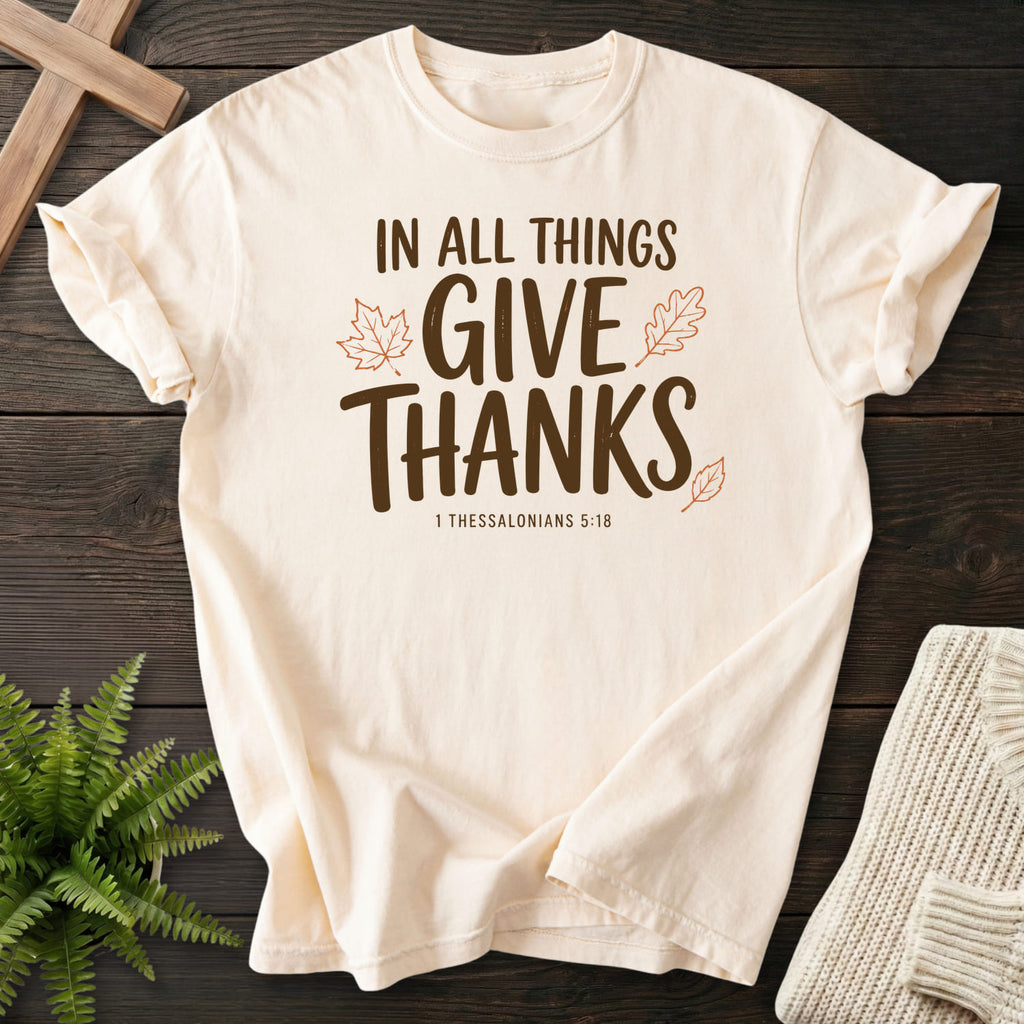 Flatlay of an Ivory Bible verse tee with "In All Things Give Thanks T-Shirt" 1 Thessalonians 5:18.