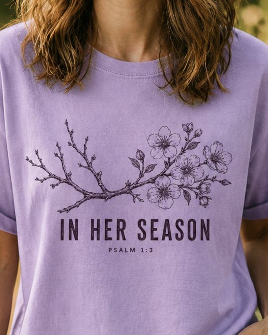 In Her Season - Orchid women's Christian tee, lifestyle photo in outdoor garden - Engraved cherry blossom branch in bloom - Psalm 1:3 - She Wears Faith