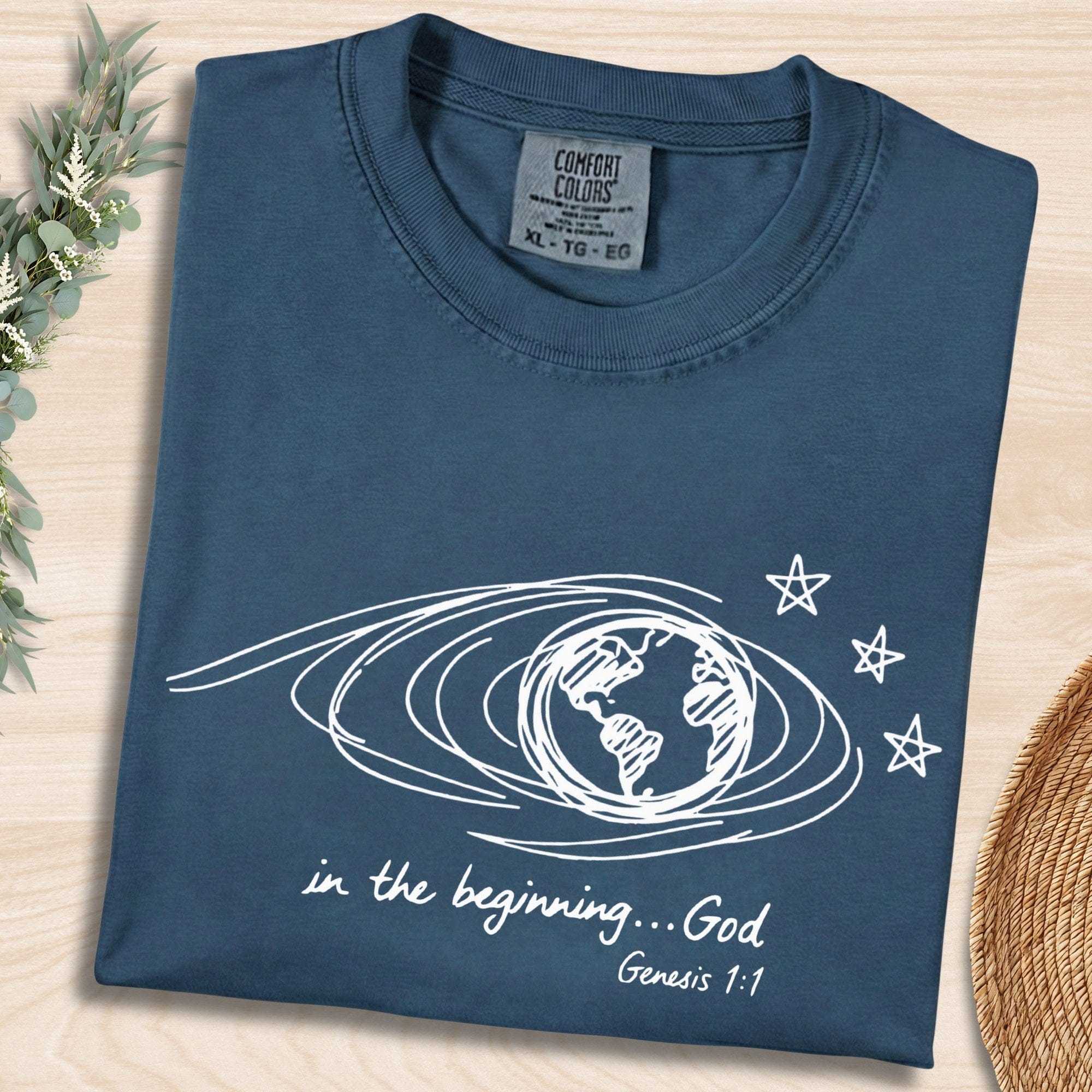 Midnight Blue Comfort Colors 1717 tshirt with white hand-drawn earth illustration and Bible verse. A vintage-style Christian women tee featuring Genesis 1:1, designed for modern US faith wear apparel.
