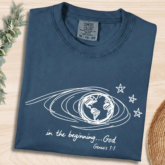 Midnight Blue Comfort Colors 1717 tshirt with white hand-drawn earth illustration and Bible verse. A vintage-style Christian women tee featuring Genesis 1:1, designed for modern US faith wear apparel.