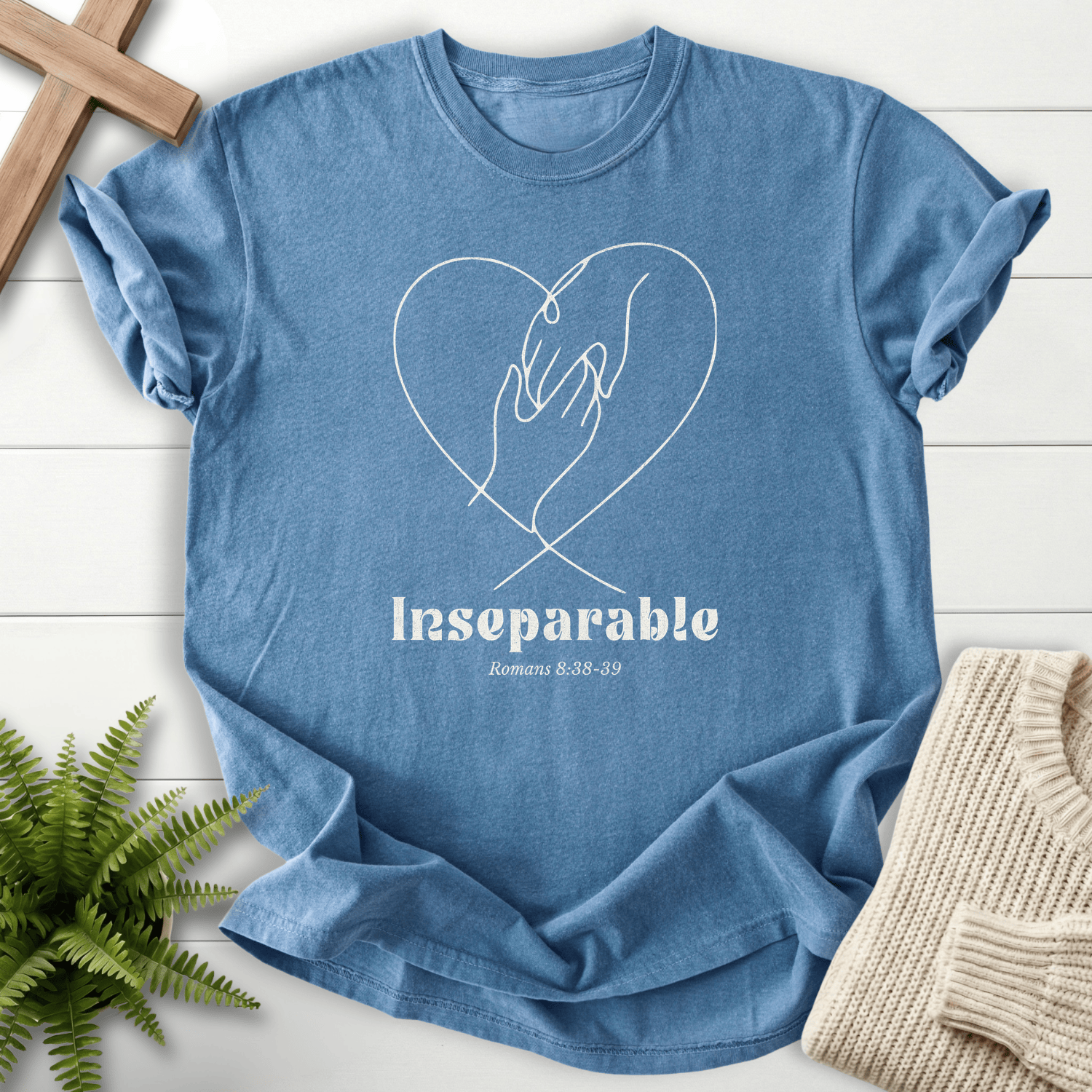 Blue Jean Christian t-shirt for women with clasped hands inside a heart line-art design, inspired by Romans 8:38-39.