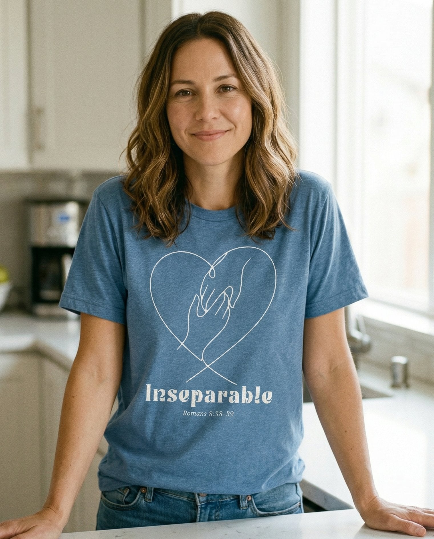 Inseparable Romans 8:38-39 – Blue Jean women's Christian tee, lifestyle photo in morning kitchen setting – Minimalist line-art of two hands clasped inside a heart outline with ' – Romans 8:38-39 – She Wears Faith