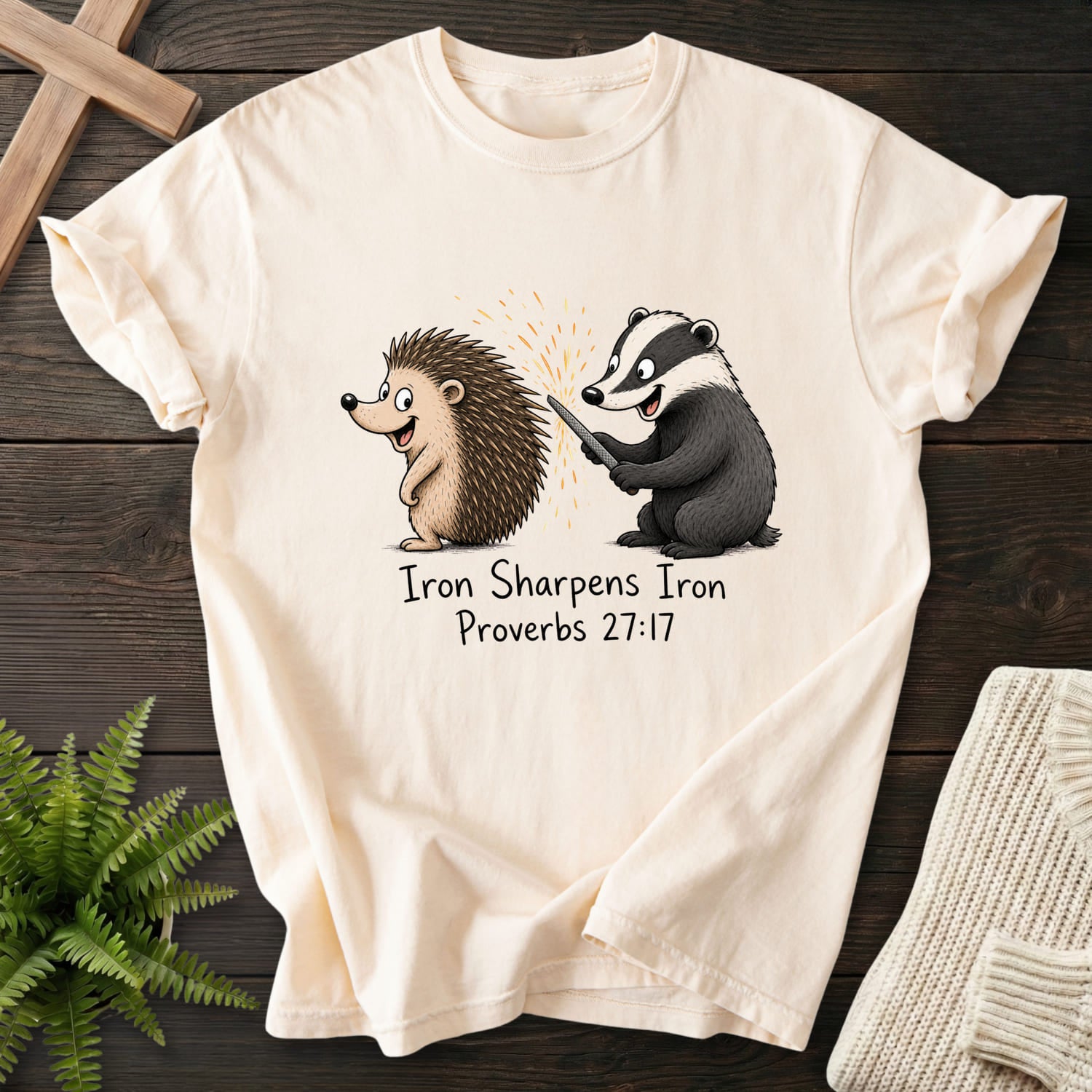 Flat lay of an Ivory Comfort Colors 1717 Scripture shirt featuring "Iron Sharpens Iron Proverbs 27:17 T-Shirt" Proverbs 27:17.