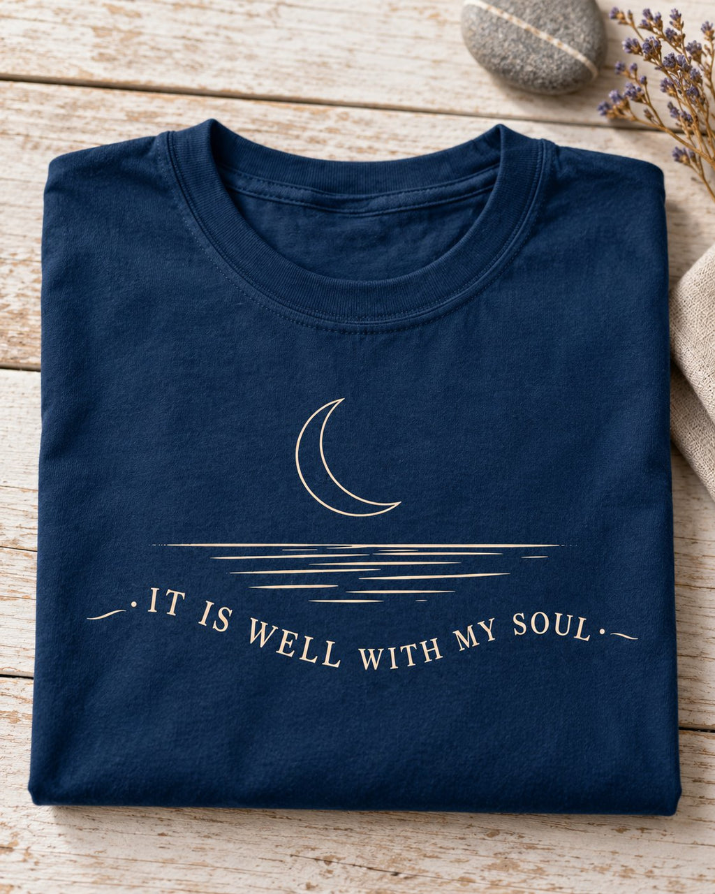It Is Well With My Soul Minimalist, Navy women's Christian tee, lifestyle photo in folded flat lay, crescent moon over water with IT IS WELL WITH MY SOUL, She Wears Faith