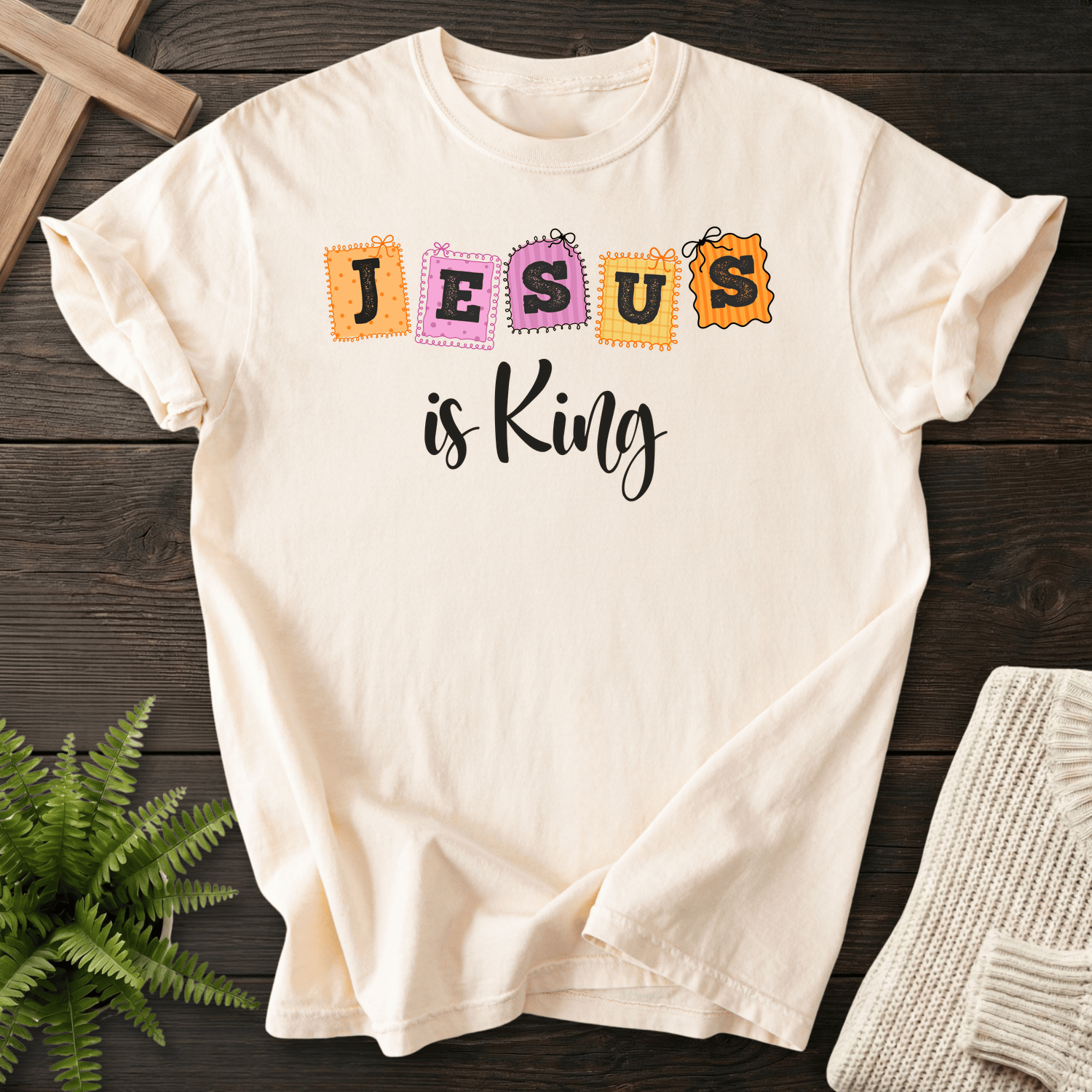 Ivory women's Christian t-shirt with playful patchwork "JESUS is King" stamp letters in orange and pink