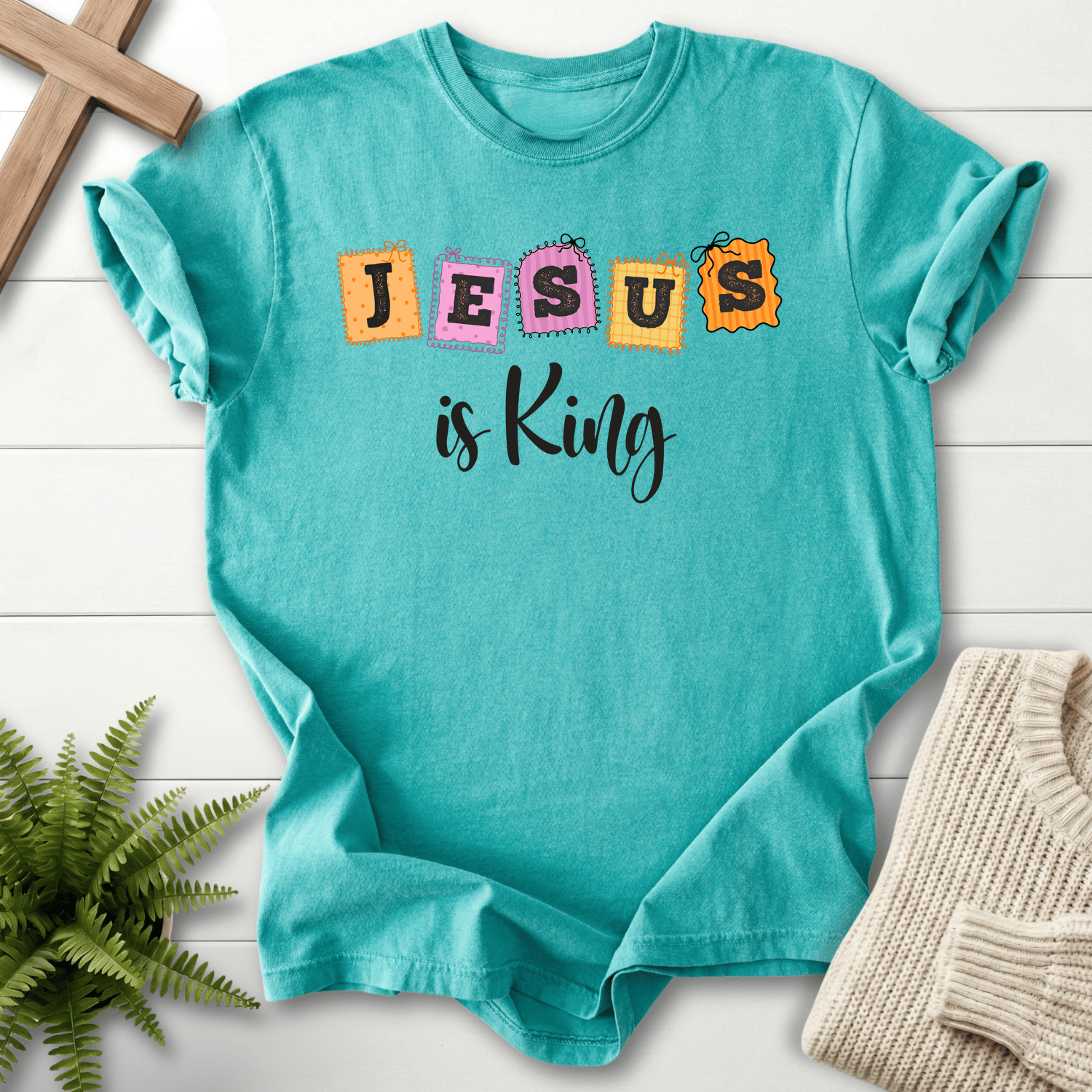 Seafoam women's Christian t-shirt with whimsical patchwork "JESUS is King" letter stamps
