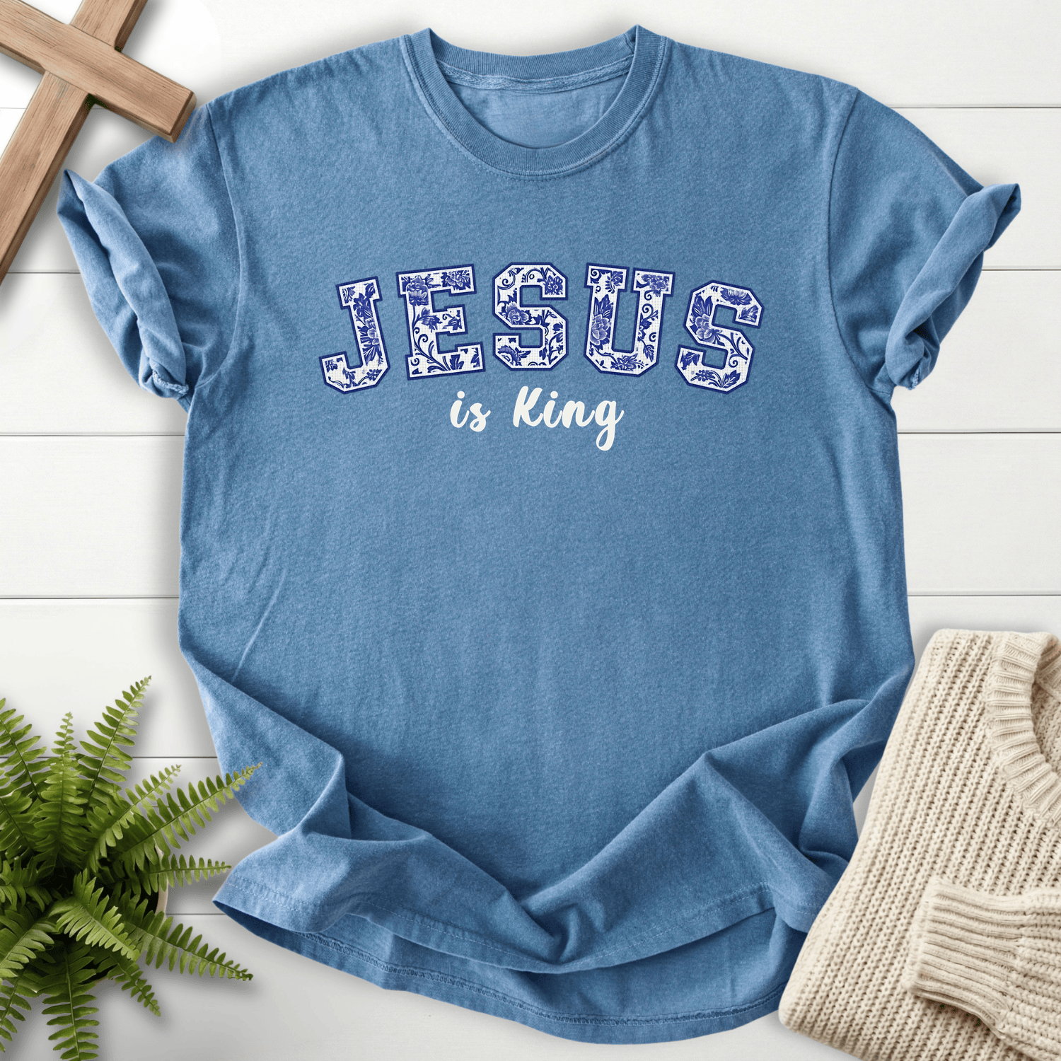 Blue Jean women's Christian t-shirt with bold floral "JESUS is King" collegiate text and white script