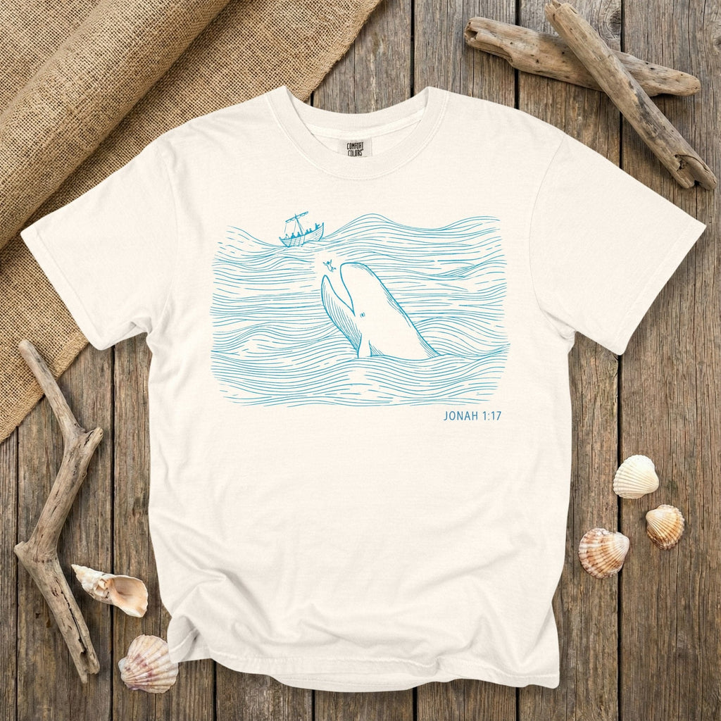 Comfort Colors 1717 ivory Christian women tee featuring a minimalist line-art illustration of Jonah and the great fish from Jonah 1:17, drawn in soft ocean-blue lines. A light, scripture-rooted US faith wear T-shirt perfect for women who love clean Biblical designs.