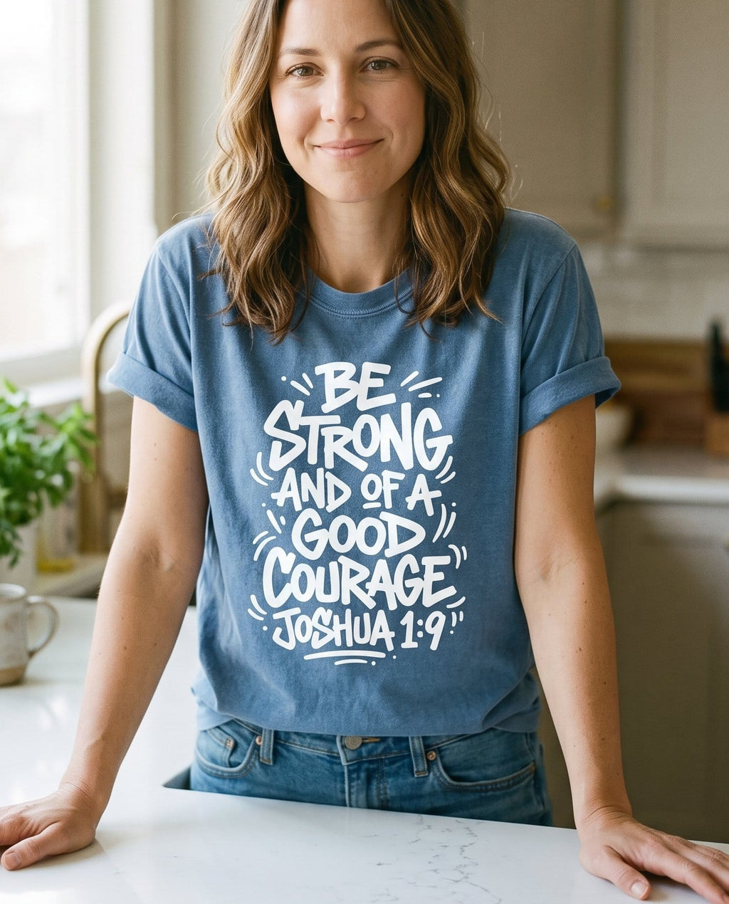Be Strong and of a Good Courage Joshua 1:9 Bubble Letter - Blue Jean women's Christian tee, lifestyle photo in morning kitchen setting - Chunky hand-drawn bubble lettering 'Be Strong and of a Good Courage' f - Joshua 1:9 - She Wears Faith