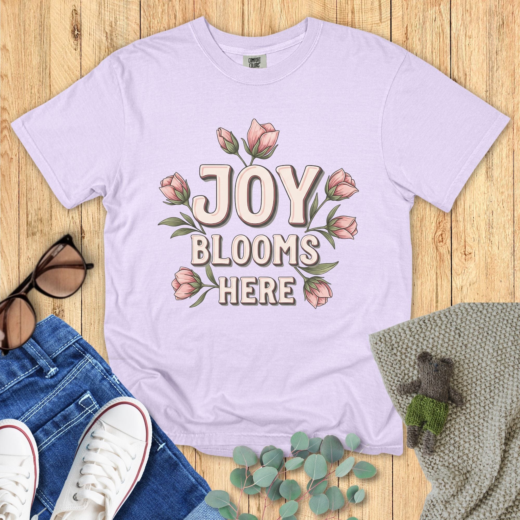 Comfort Colors 1717 orchid “Joy Blooms Here” t-shirt in light lavender featuring pink floral design. A feminine women’s scripture tee — refreshing faith-based apparel for women and perfect Christian mom gift idea full of hope and positivity.