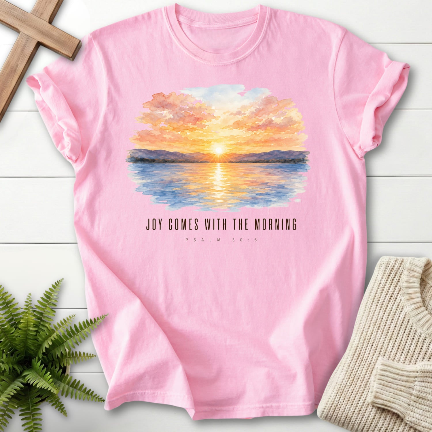 Flat lay of a Blossom Christian t-shirt for women featuring watercolor artwork with "Joy Comes With the Morning T-Shirt".