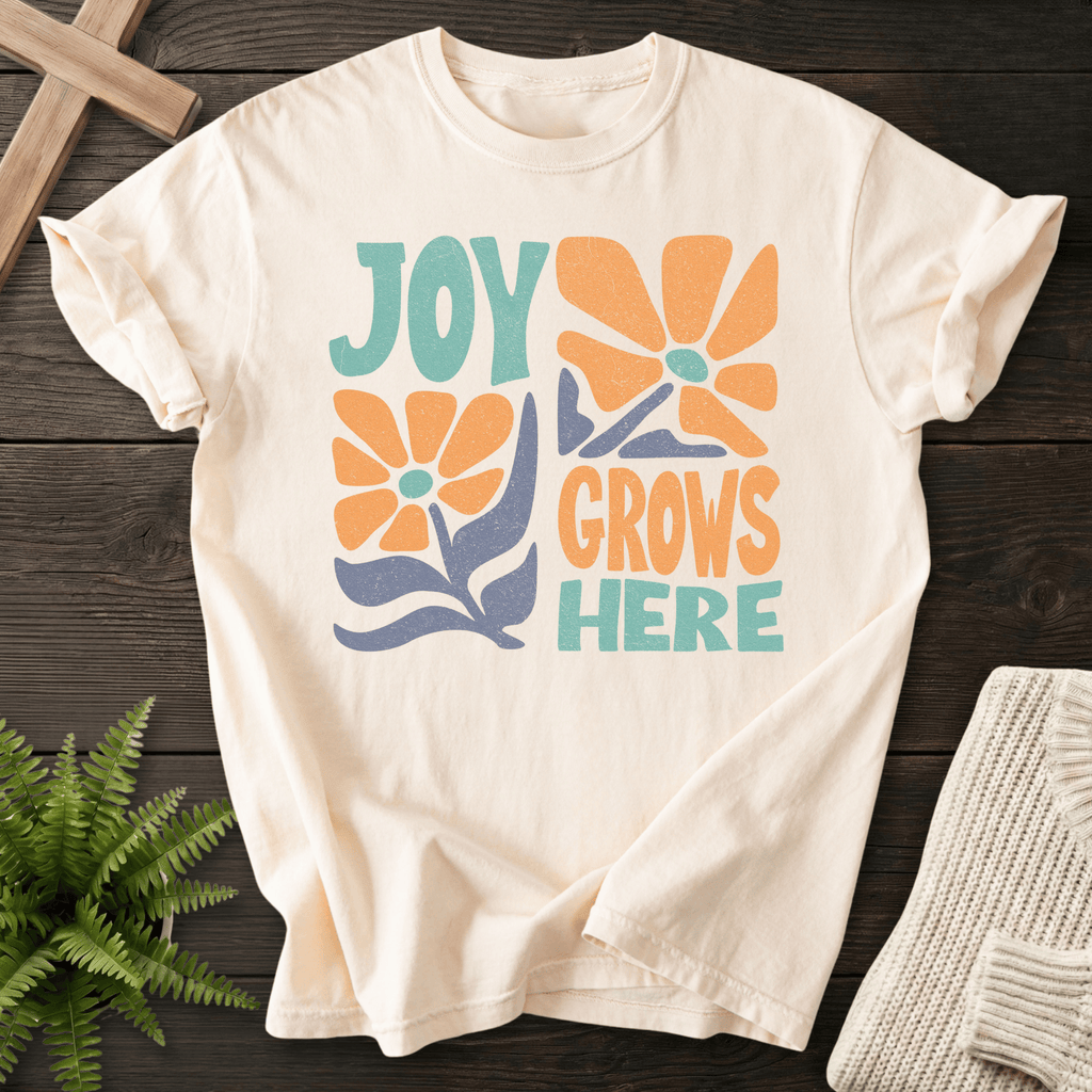 Ivory women's Christian t-shirt with groovy "Joy Grows Here" orange daisy flowers and teal block text