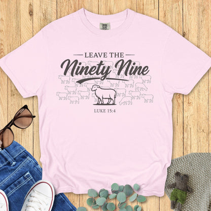 Flatlay of a Comfort Colors 1717 blossom “Leave the Ninety-Nine – Luke 15:4” t-shirt with a lost sheep illustration. A graceful and inspiring women’s scripture tee — faith-based apparel for women and meaningful Christian mom gift that celebrates Luke 15:4.
