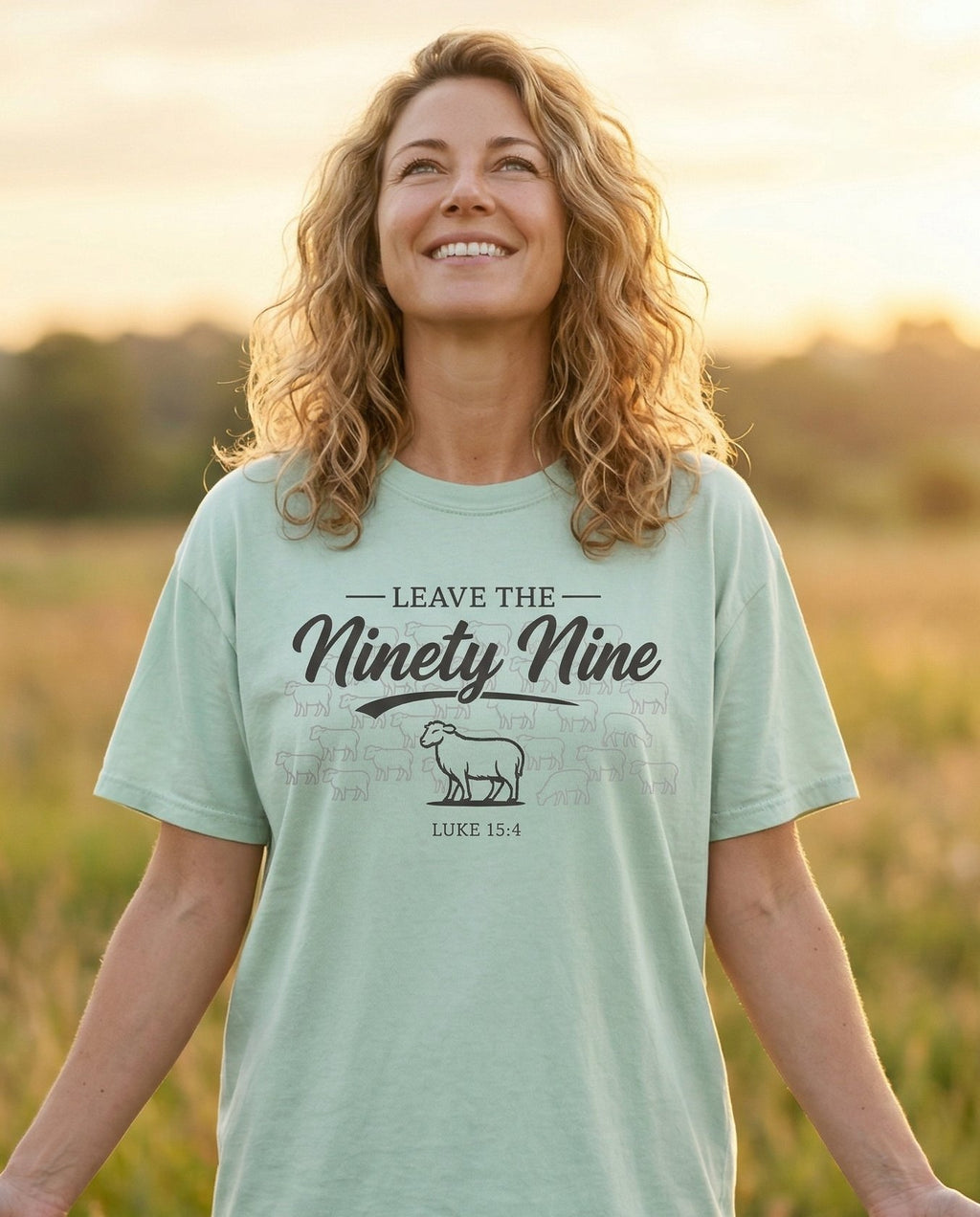 Leave the Ninety Nine T-shirt – Bay women's Christian tee, lifestyle photo in wildflower meadow at sunrise – Vintage western script reading 'Leave the Ninety Nine' with an illustr – Luke 15:4 – She Wears Faith