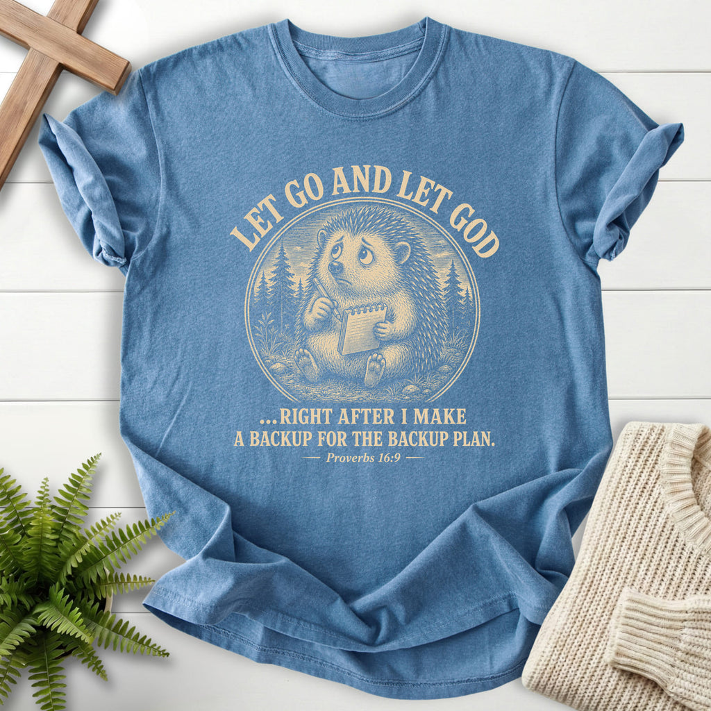 Flatlay of a Blue Jean Scripture shirt with "Let Go and Let God Backup Plan T-Shirt" Proverbs 16:9.