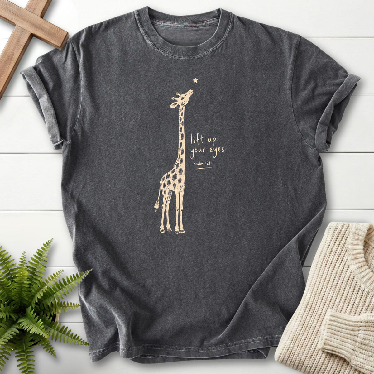 Flatlay of a Pepper Bible verse tee with "Lift Up Your Eyes Giraffe T-Shirt" Psalm 121:1.
