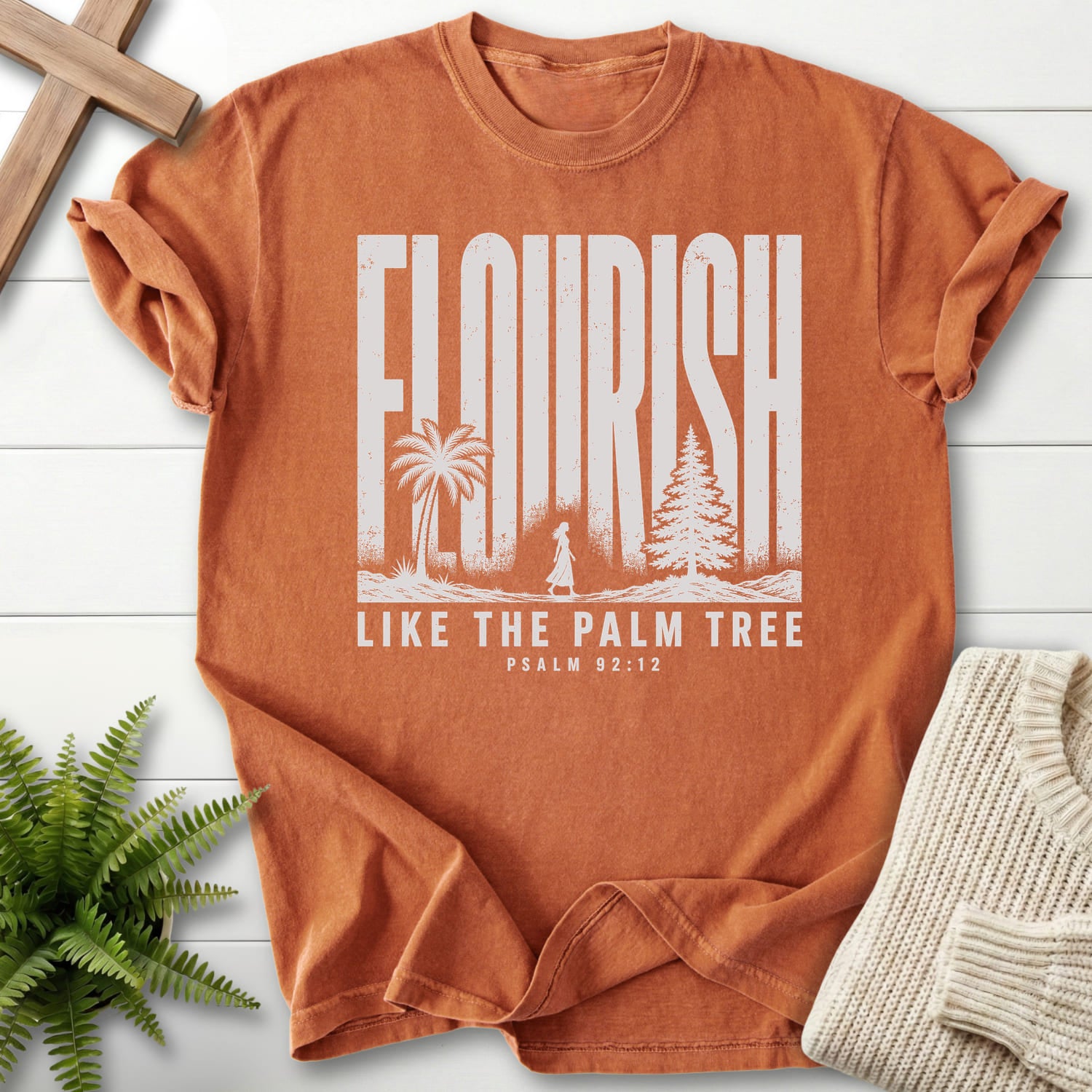 Flat lay of a Yam women's Christian tee featuring "Like The Palm Flourish Scripture T-Shirt" Psalm 92:12.