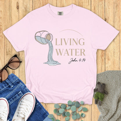 Comfort Colors 1717 blossom “Living Water – John 4:14” t-shirt in soft pink with clean line art of a pouring jug. A gentle women’s scripture tee — uplifting faith-based apparel for women and pretty modern Christian shirt, ideal for Christian mom gift ideas.